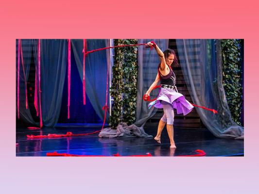 twirl shot of female dancer with red rope on stage