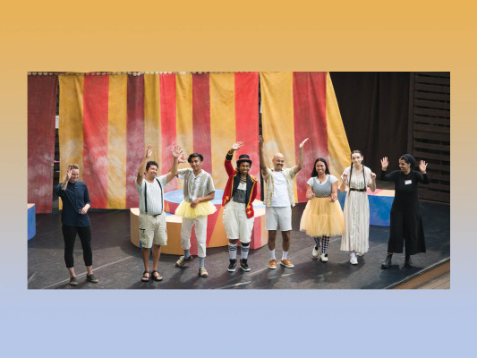 actors waving hands to audience on stage